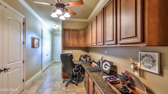 office space featuring built in desk, ceiling fan, and crown molding