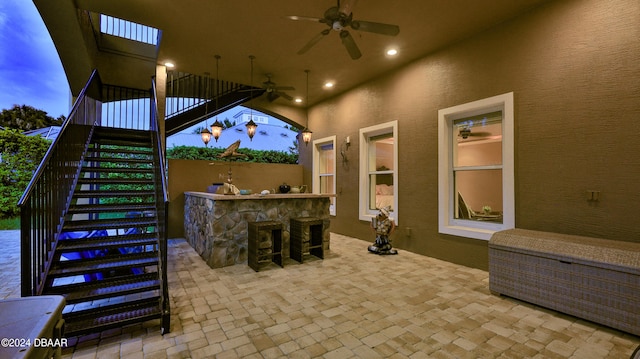 view of patio with ceiling fan, area for grilling, and exterior bar