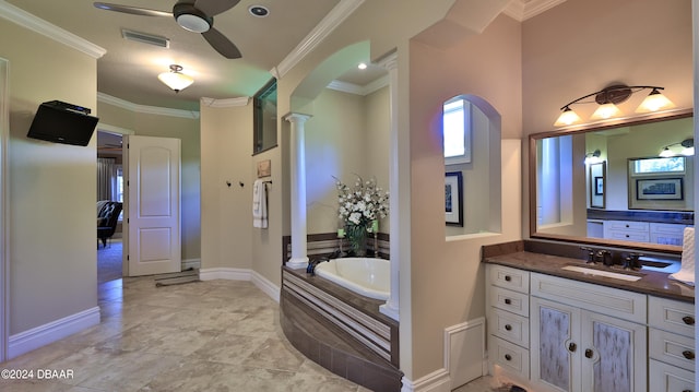 bathroom featuring vanity, ornate columns, crown molding, and tiled tub