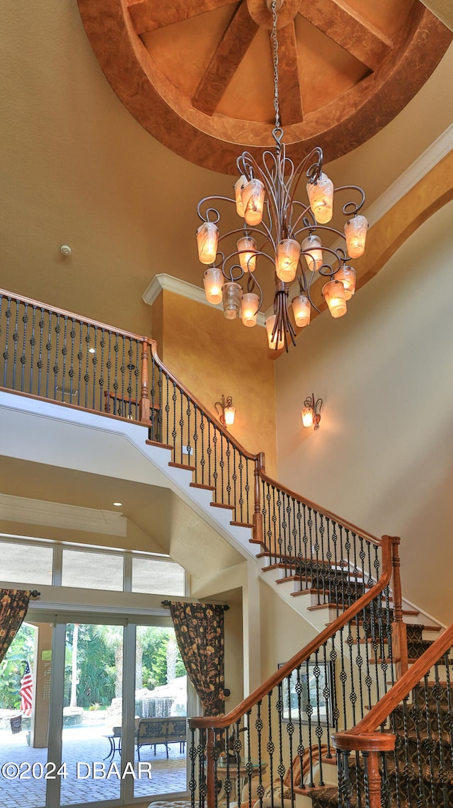 stairway with a chandelier and a towering ceiling