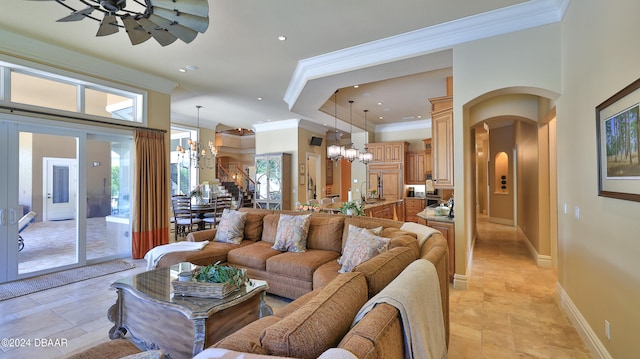 living room with ceiling fan with notable chandelier, crown molding, and sink