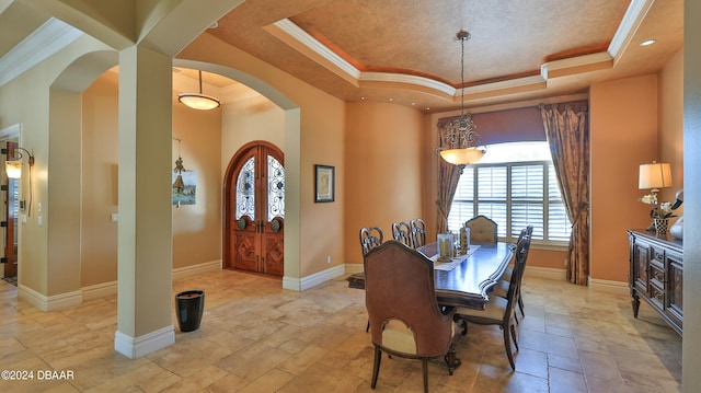 dining area featuring a tray ceiling and ornamental molding