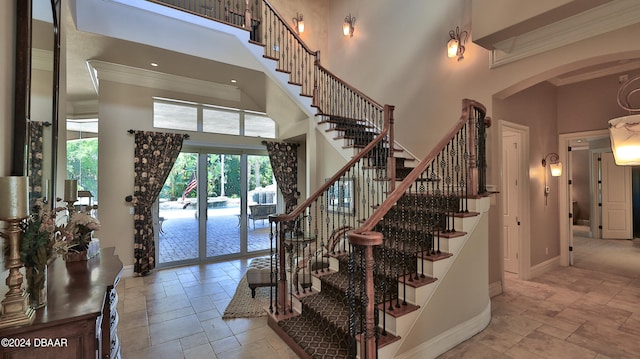 stairs with a towering ceiling and ornamental molding