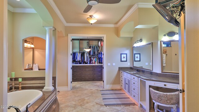 bathroom featuring ornate columns, ceiling fan, crown molding, a bathtub, and vanity