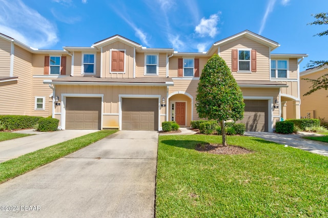 townhome / multi-family property with a garage and a front lawn