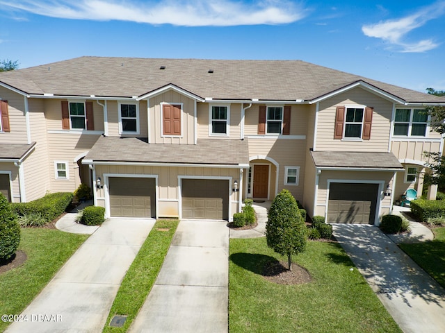 view of property with a garage and a front lawn