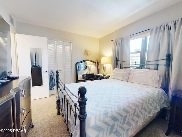 bedroom with carpet floors, visible vents, and a closet