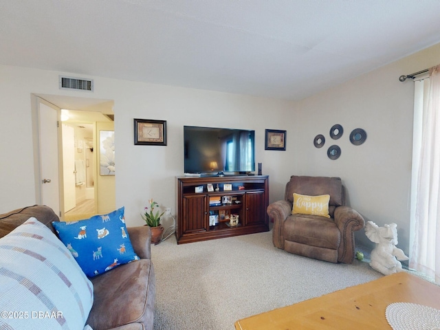 living area featuring visible vents and carpet floors