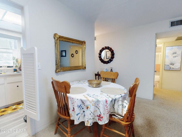 dining room with visible vents and light carpet