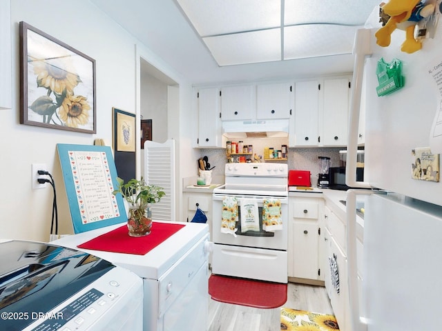 kitchen with washing machine and dryer, light wood-type flooring, light countertops, under cabinet range hood, and white appliances