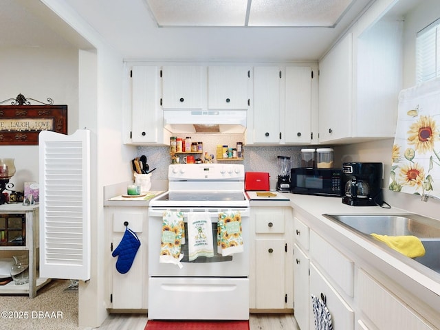 kitchen with under cabinet range hood, black microwave, white range with electric cooktop, and tasteful backsplash