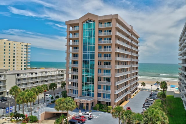 view of property with a water view and a view of the beach