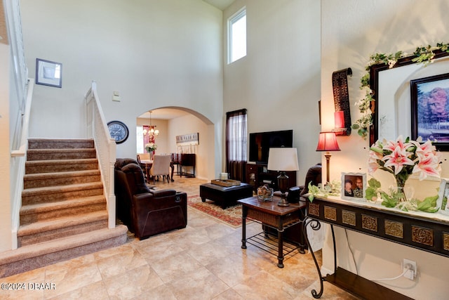 living room with a towering ceiling and an inviting chandelier