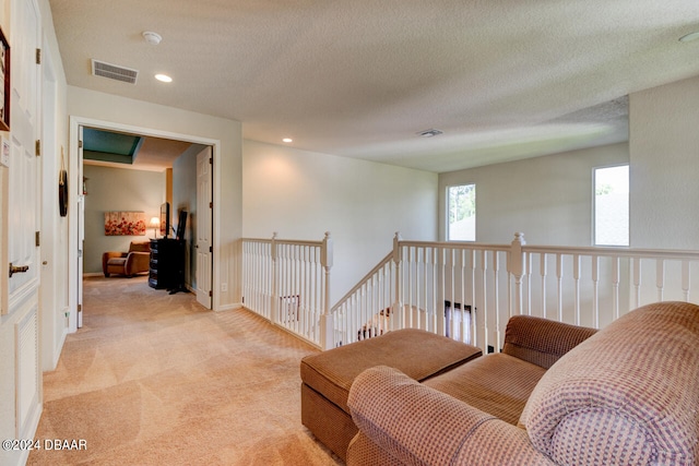 sitting room featuring light colored carpet and a textured ceiling