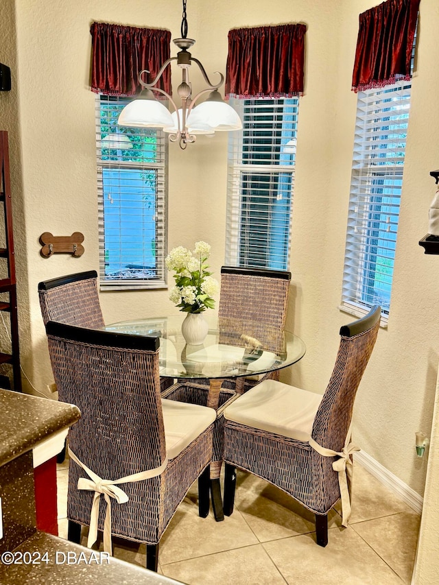 tiled dining space with an inviting chandelier