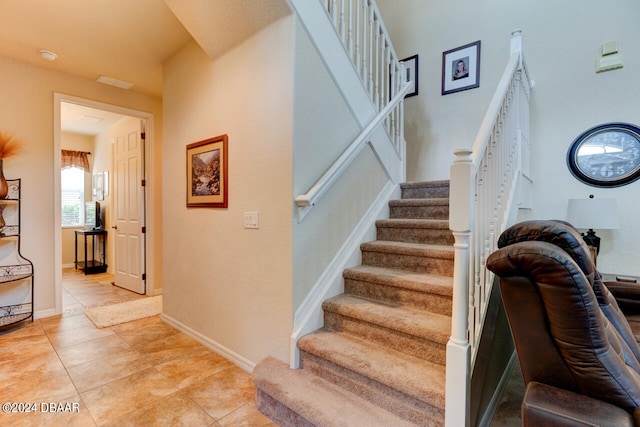 stairway with tile patterned floors