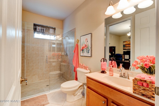 bathroom with toilet, vanity, tile patterned floors, and a shower with door