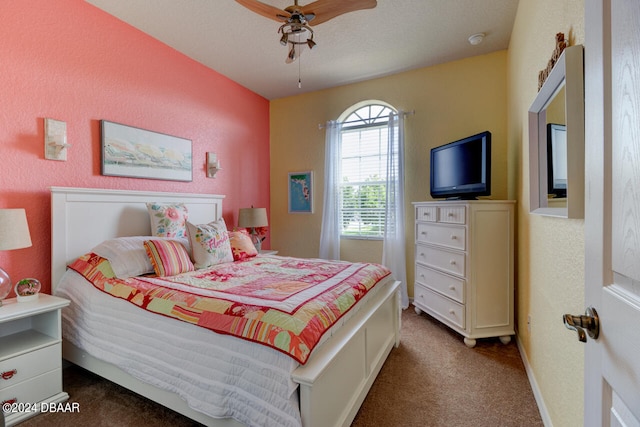 bedroom with ceiling fan, a textured ceiling, and dark carpet