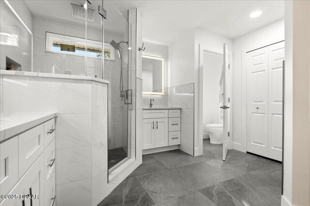 1589 Town Park Dr, Port Orange, FL 32129 - bathroom with vanity, toilet, an enclosed shower, and tile walls