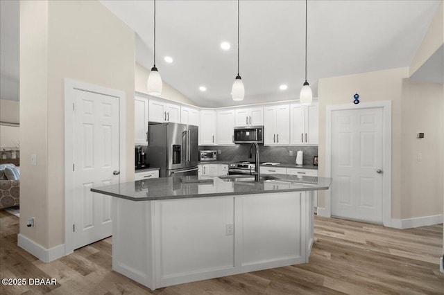 1589 Town Park Dr, Port Orange, FL 32129 - kitchen with sink, white cabinetry, dark stone countertops, stainless steel appliances, and a kitchen island with sink