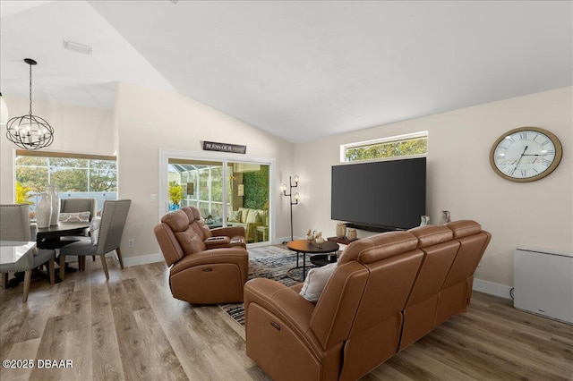 1589 Town Park Dr, Port Orange, FL 32129 - living room featuring high vaulted ceiling, light hardwood / wood-style floors, and a notable chandelier