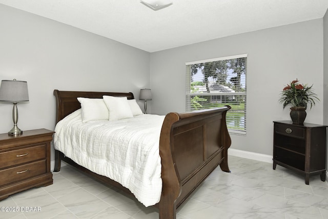 bedroom with baseboards and marble finish floor