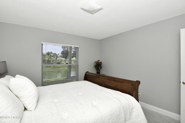 bedroom with baseboards and marble finish floor