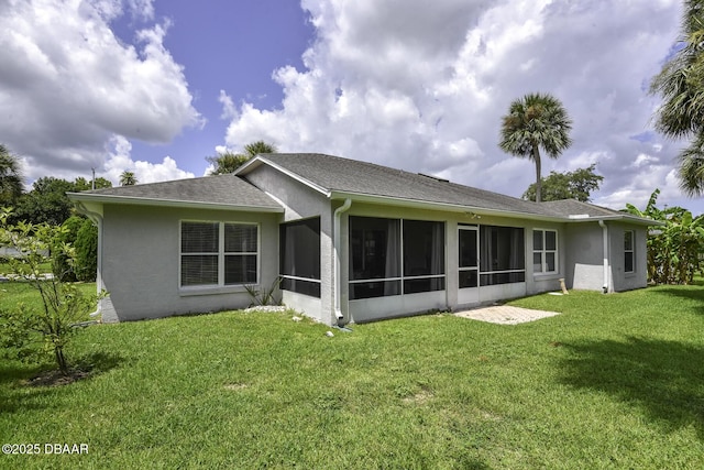 back of property featuring stucco siding, a shingled roof, a yard, and a sunroom