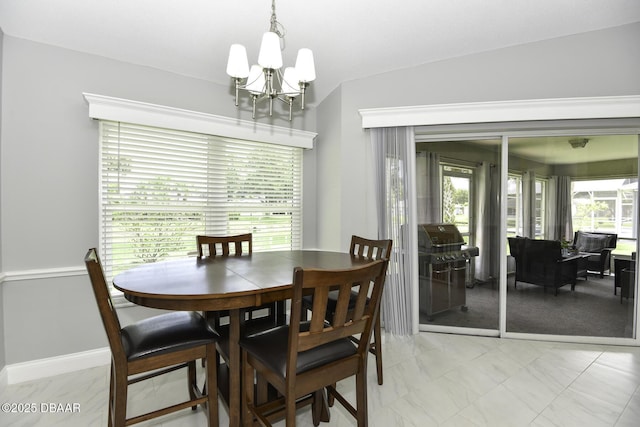 dining room featuring a wealth of natural light, marble finish floor, baseboards, and an inviting chandelier