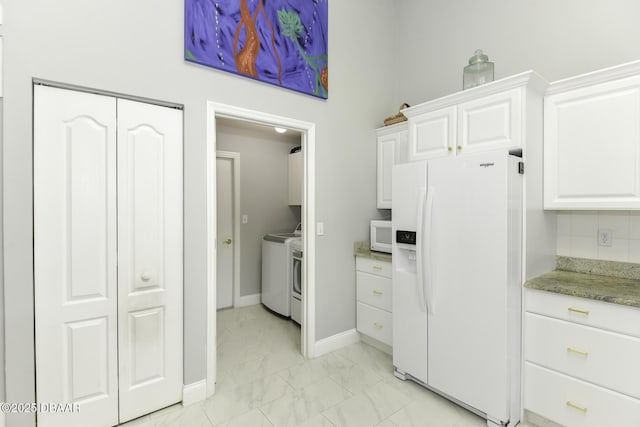 kitchen with white appliances, separate washer and dryer, decorative backsplash, white cabinets, and marble finish floor