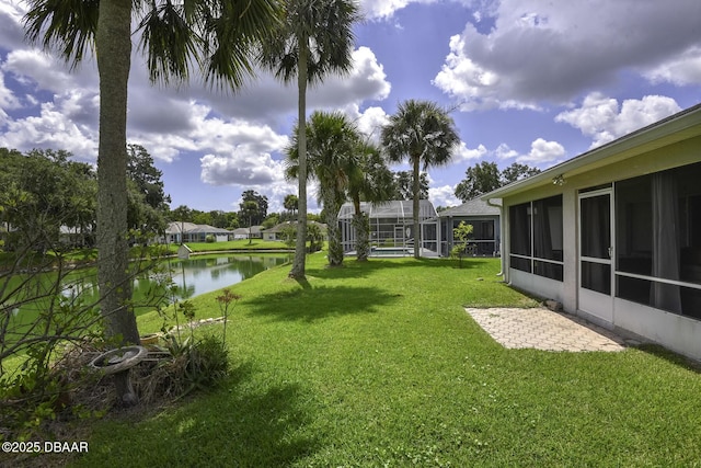 view of yard featuring glass enclosure and a water view