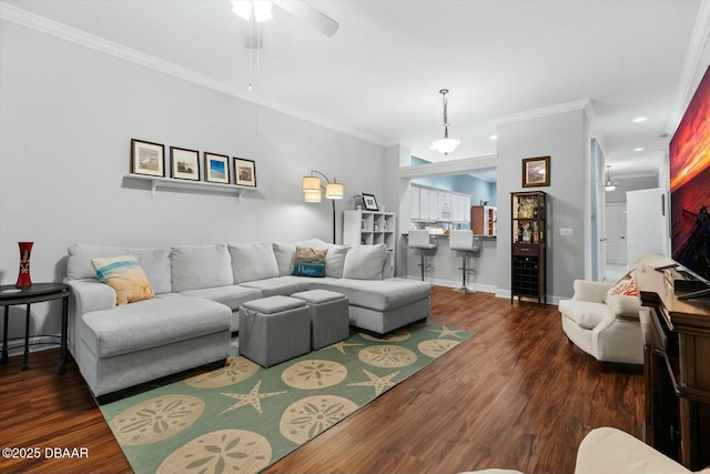 living room featuring dark hardwood / wood-style flooring, ceiling fan, and crown molding