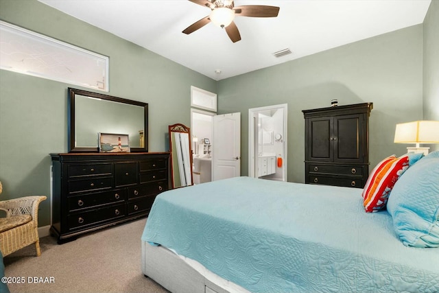 carpeted bedroom with ensuite bath and ceiling fan