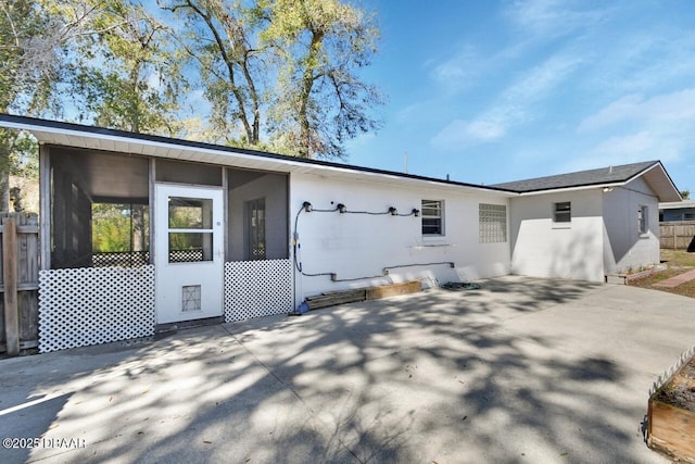 exterior space with a patio area, fence, and a sunroom