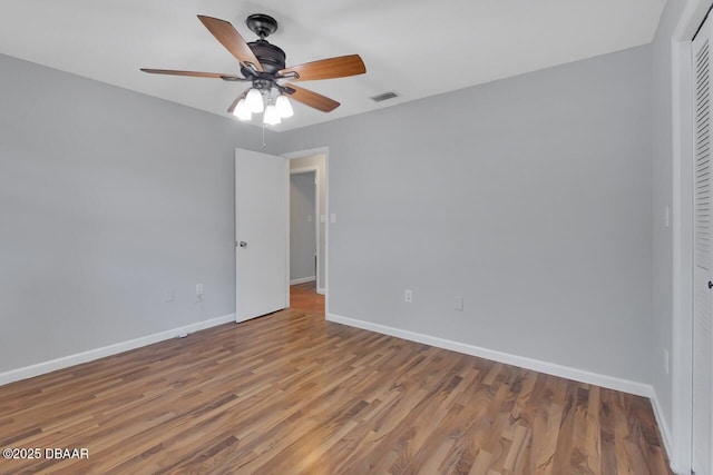 unfurnished bedroom with a closet, visible vents, baseboards, and wood finished floors