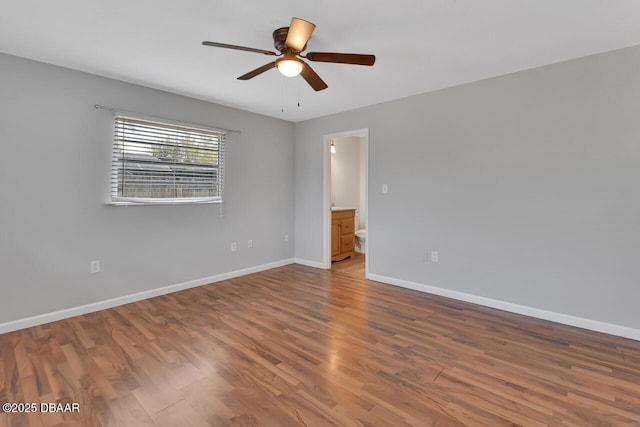 unfurnished room featuring ceiling fan, wood finished floors, and baseboards