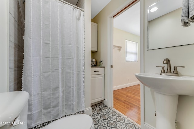 556 N Beach St, Ormond Beach, FL 32174 - bathroom featuring toilet, baseboards, a shower with shower curtain, and a sink