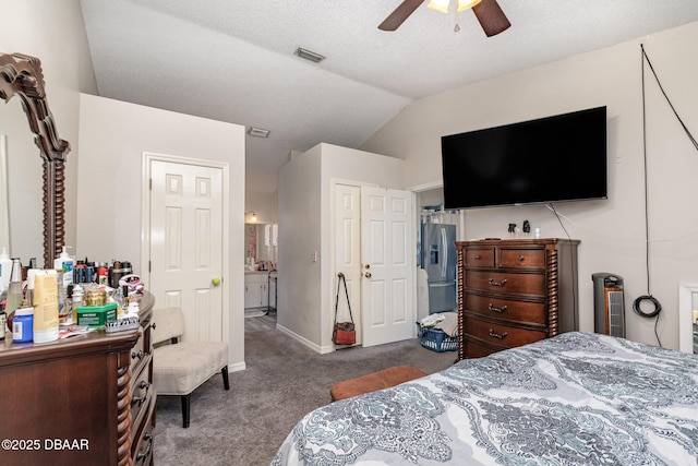 bedroom with stainless steel fridge, a textured ceiling, vaulted ceiling, ceiling fan, and dark colored carpet