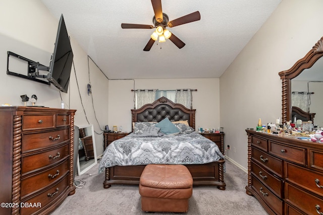 carpeted bedroom with ceiling fan and a textured ceiling