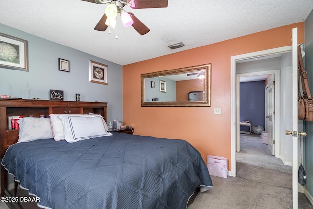 carpeted bedroom with ceiling fan and a textured ceiling