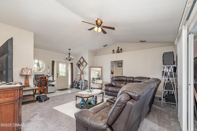 carpeted living room featuring vaulted ceiling, ceiling fan with notable chandelier, and a textured ceiling