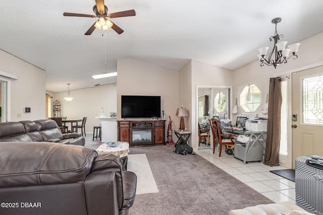 tiled living room featuring ceiling fan with notable chandelier and lofted ceiling