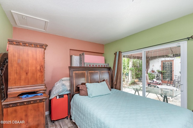 bedroom with access to outside and hardwood / wood-style floors