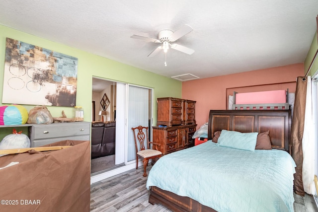 bedroom featuring ceiling fan, light hardwood / wood-style flooring, and a textured ceiling