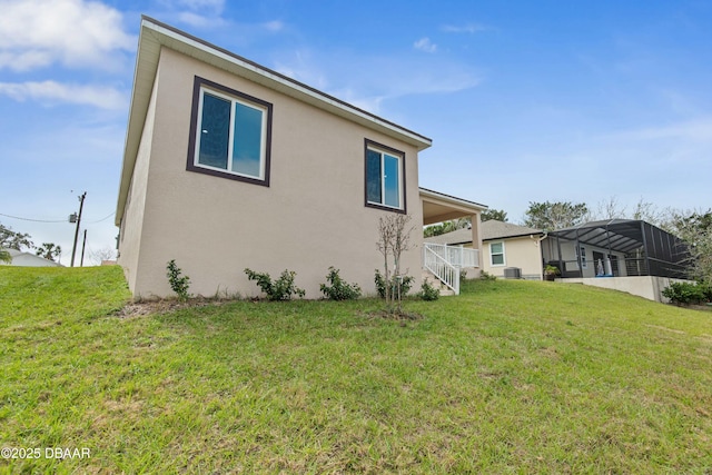 exterior space featuring cooling unit, a yard, and glass enclosure