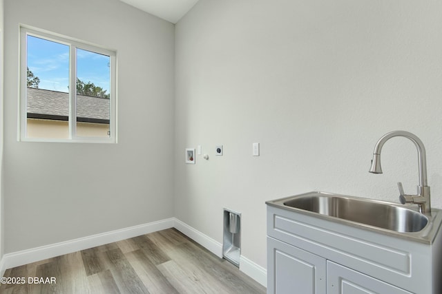 laundry room featuring sink, hookup for a washing machine, cabinets, hookup for an electric dryer, and light wood-type flooring