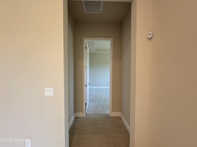 corridor with tile patterned floors, baseboards, and visible vents