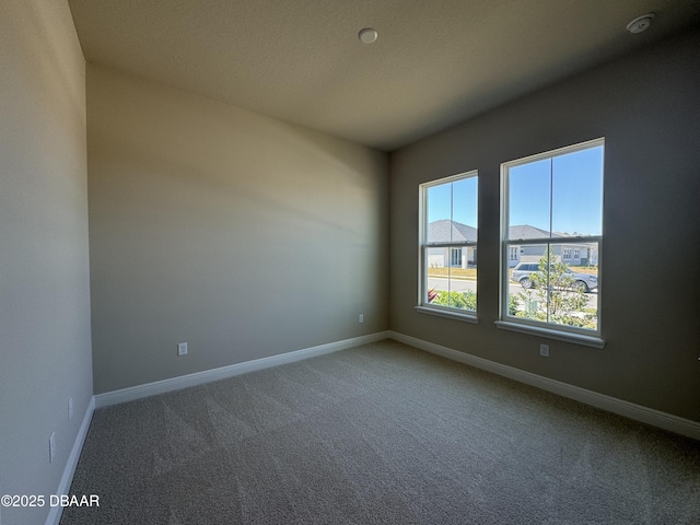 carpeted empty room with baseboards