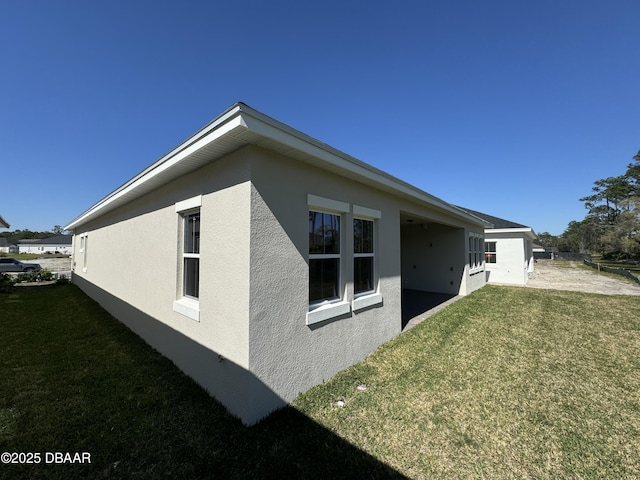 view of home's exterior featuring a lawn and stucco siding