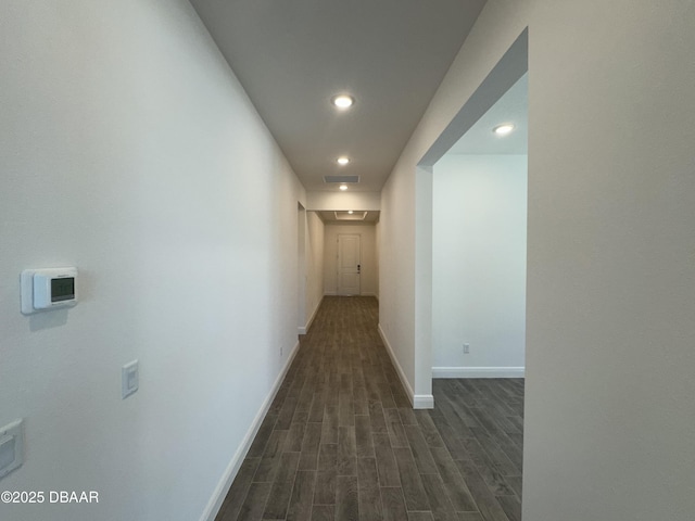 corridor featuring dark wood finished floors, recessed lighting, and baseboards